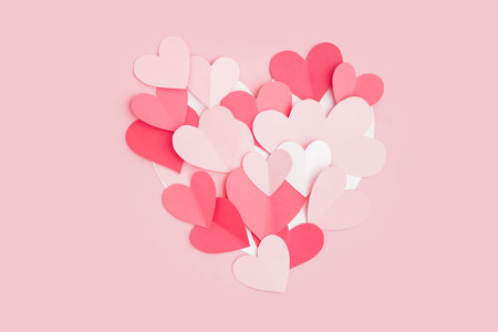Paper hearts on pink background. Valentine's Day celebration