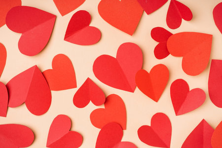 Red paper hearts on yellow background. Valentine's Day celebration
