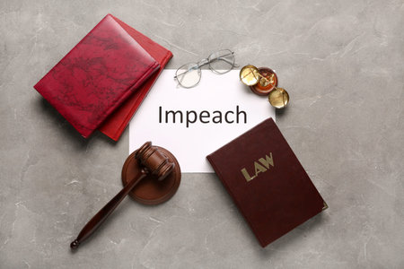 Paper with word IMPEACH, judge gavel, scales of justice and law books on gray grunge background