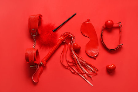 Composition with different sex toys and hearts on red background. Valentine's Day celebration