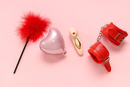 Composition with sex toys and heart-shaped balloon on pink background. Valentine's Day celebrationの写真素材