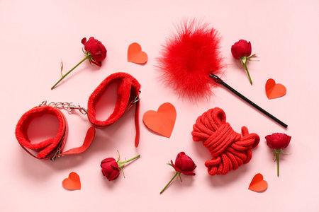 Composition with sex toys, rose flowers and paper hearts on pink background. Valentine's Day...