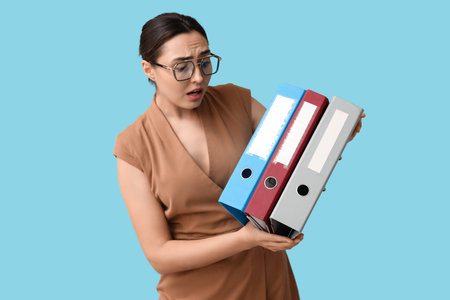 Stressed businesswoman with document folders on blue background