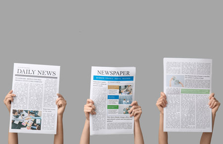 Women with newspapers on gray backgroundの写真素材