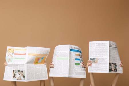Women with newspapers on brown backgroundの写真素材