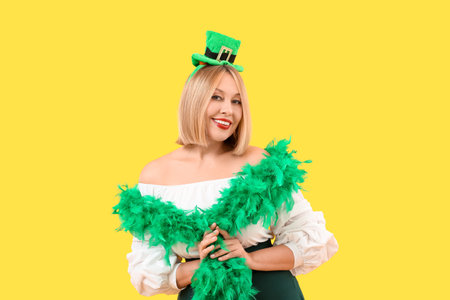 Happy woman in party clothes on yellow background. St. Patrick's Dayの写真素材