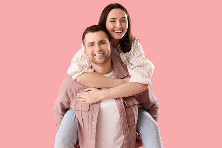 Happy young couple hugging on pink backgroundの写真素材