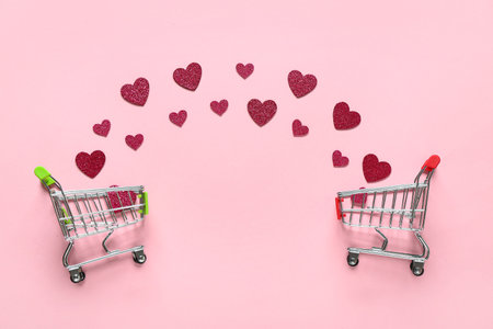 Small shopping cards with paper hearts on pink background. Valentine's Day celebrationの写真素材