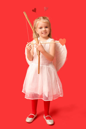 Cute little girl dressed as cupid with arrow and bow on red background. Valentine's Day celebration
