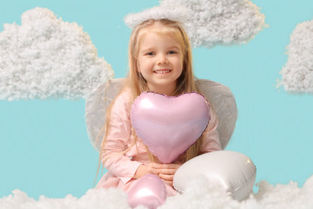 Cute little girl dressed as cupid with heart-shaped balloons and clouds on blue background....