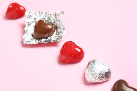 Tasty heart-shaped chocolate candies on pink background. Valentine's Day celebrationの写真素材