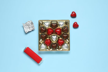 Box with tasty chocolate candies on blue background. Valentine's Day celebration