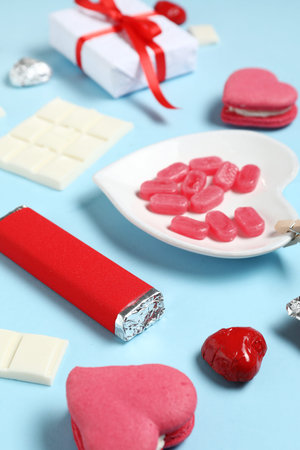 Different tasty sweets with gift box on blue background. Valentine's Day celebration