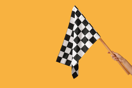 Woman with racing flag on yellow backgroundの写真素材