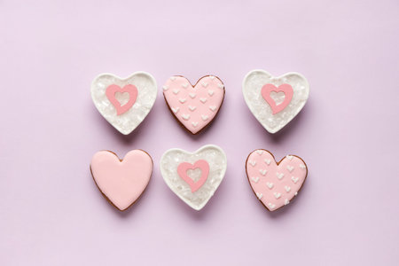 Heart shaped sweet cookies and bowls with snow on lilac background. Valentine's day celebration