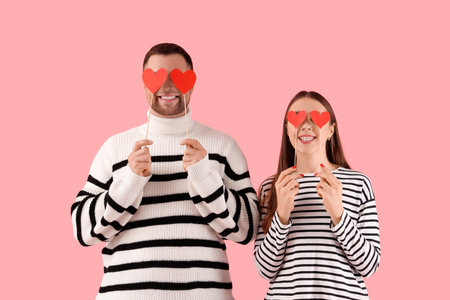Lovely couple with paper hearts on pink background. Valentine's Day celebrationの写真素材