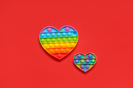 Heart-shaped pop it fidget toys on red background. Valentine's day celebrationの写真素材