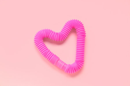 Pop Tube in the shape of heart on pink background. Valentine's day celebrationの写真素材