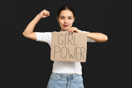 Young woman with sign GIRL POWER on black background. Feminism conceptの写真素材