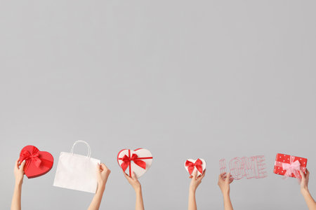Women with shopping bag, gifts and word LOVE on light background. Valentine's Day celebrationの写真素材