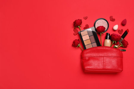Cosmetic bag with make up products and roses on red background. Valentine's day celebrationの写真素材