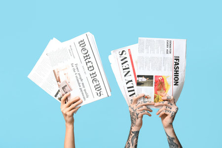 Female and male hands with newspapers on blue backgroundの写真素材