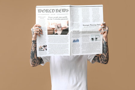 Man with newspaper on beige backgroundの写真素材