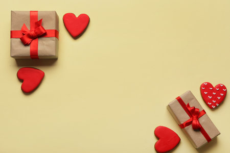 Heart shaped sweet cookies and gift boxes on yellow background. Valentine's day celebrationの写真素材
