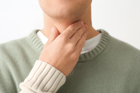 Young man with thyroid gland problem at home, closeup