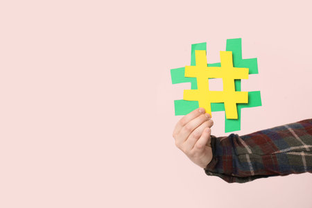 Man with hashtag signs on pink background