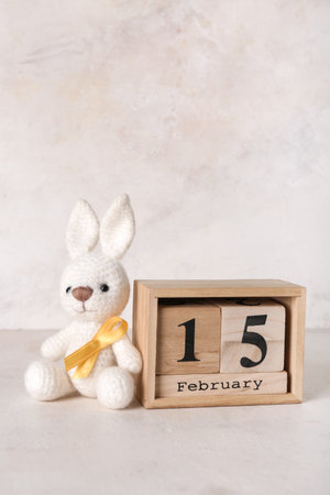 Toy bunny with golden ribbon and calendar on white grunge background. Childhood cancer awareness conceptの写真素材