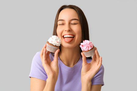 Young woman with sweet cupcakes on white background. Valentine's Day celebrationの写真素材