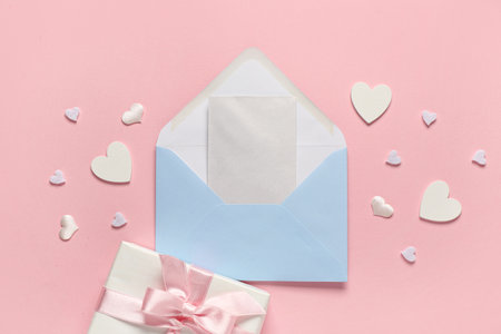 Blue envelope with card, gift and hearts on pink background. Valentine's Day celebrationの写真素材