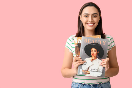 Beautiful woman with magazines on pink backgroundの写真素材