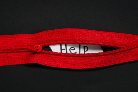Zip and paper with word HELP on dark background. Domestic violence conceptの写真素材