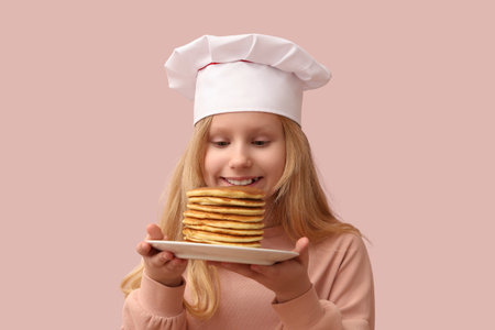 Little chef with tasty pancakes on beige backgroundの写真素材
