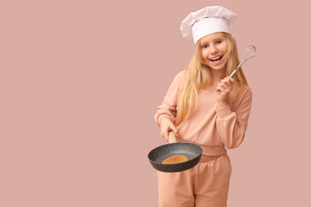 Little chef with tasty pancakes on frying pan against beige backgroundの写真素材