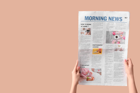 Woman with newspaper on beige backgroundの写真素材