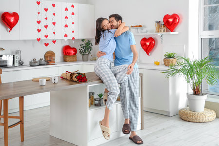 Happy young couple hugging in kitchen on Valentine's Dayの写真素材