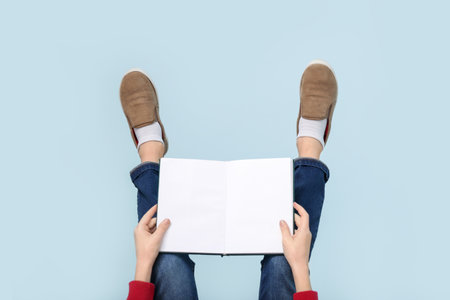 Legs of little boy with book on blue backgroundの写真素材
