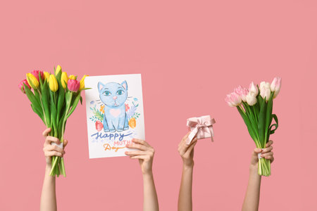 Women with gift, tulips and drawing on pink background. Mother's Day celebrationの写真素材