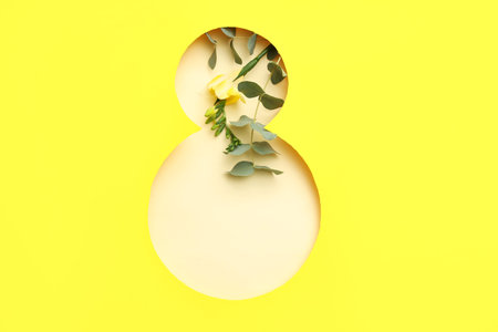 Cut paper in shape of figure 8 with beautiful flower on yellow background. International Women's Dayの写真素材