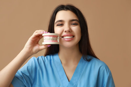 Female dentist with jaw model on brown background. World Dentist Dayの写真素材