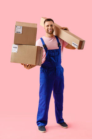 Male courier with parcels on pink background