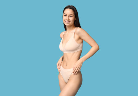 Beautiful young woman in underwear on blue background. Epilation conceptの写真素材