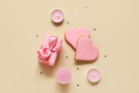 Heart shaped cookies with gift box and candles on yellow background. Valentine's Day celebrationの写真素材