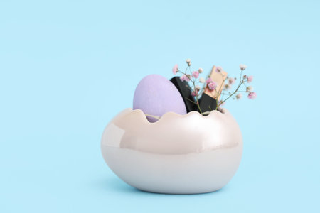 Basket in shape of Easter egg with lipsticks and flowers on blue background