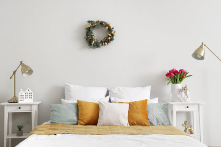 Interior of light bedroom with Easter wreath and tablesの写真素材