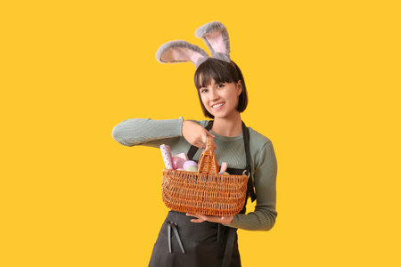 Female hairdresser in bunny ears with Easter eggs on yellow background
