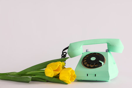 Retro telephone and beautiful yellow tulips on lilac background. International Women's Dayの写真素材